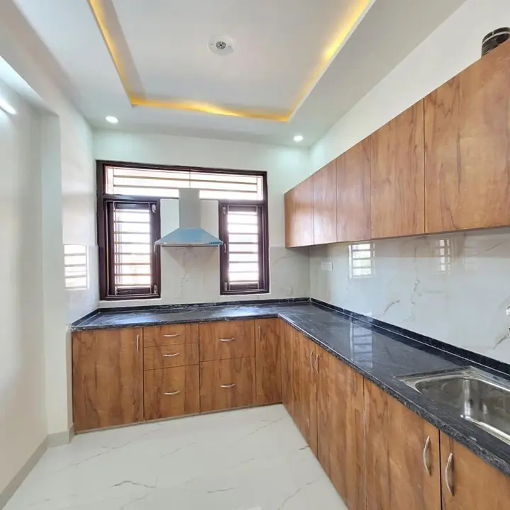 L-shaped wood laminate modular kitchen with black granite top – VS Interiors, Wagholi