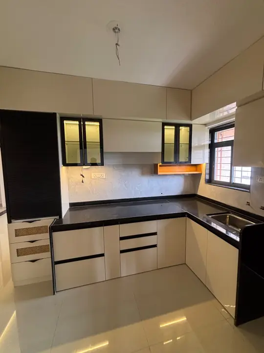 White and black L-shaped modular kitchen with glass uppers – VS Interiors, Wagholi