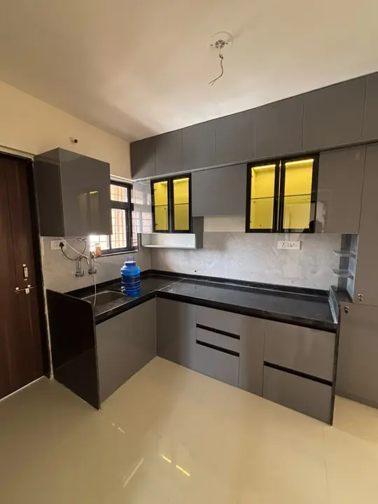 Graphite grey L-shaped kitchen with yellow-lit glass uppers – VS Interiors, Wagholi