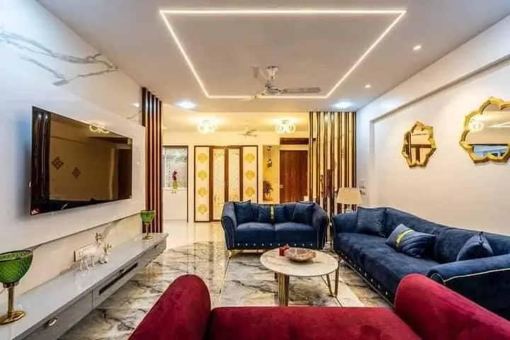 Blue and gold living room with marble TV wall and cove ceiling – VS Interiors, Wagholi